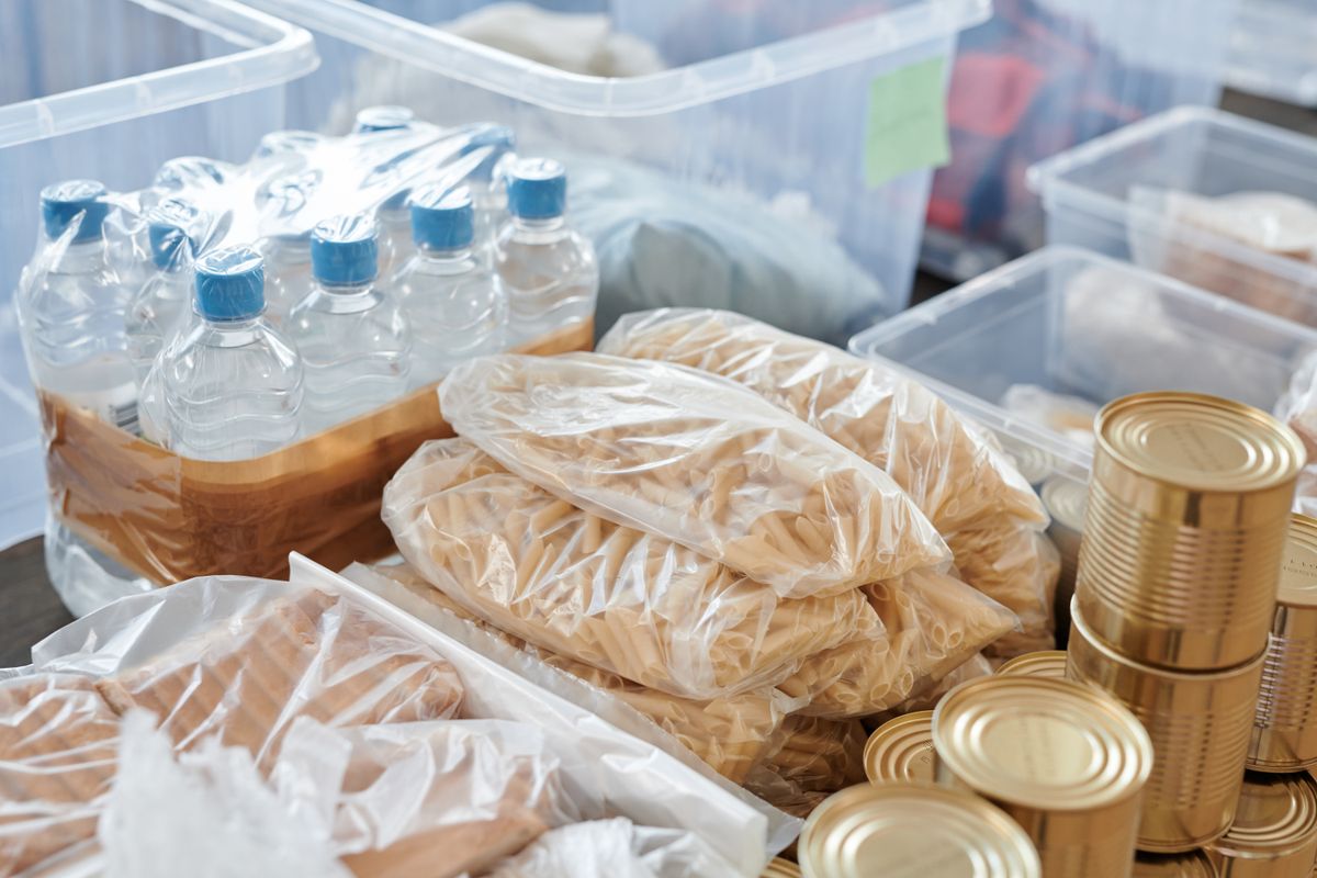 Food in cans and plastic bags organized for bulk food storage and preservation in commercial setting