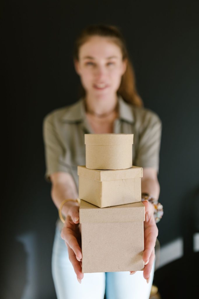 Small business owner holding branded packaging boxes