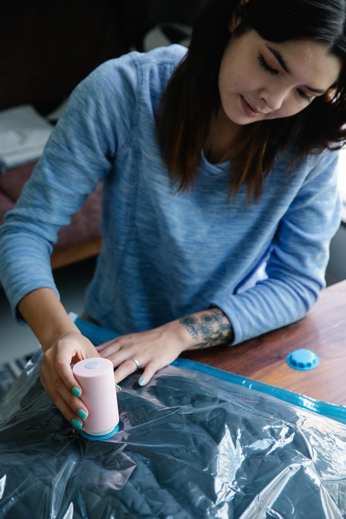 Woman using vacuum compression bag to pack clothes for moving