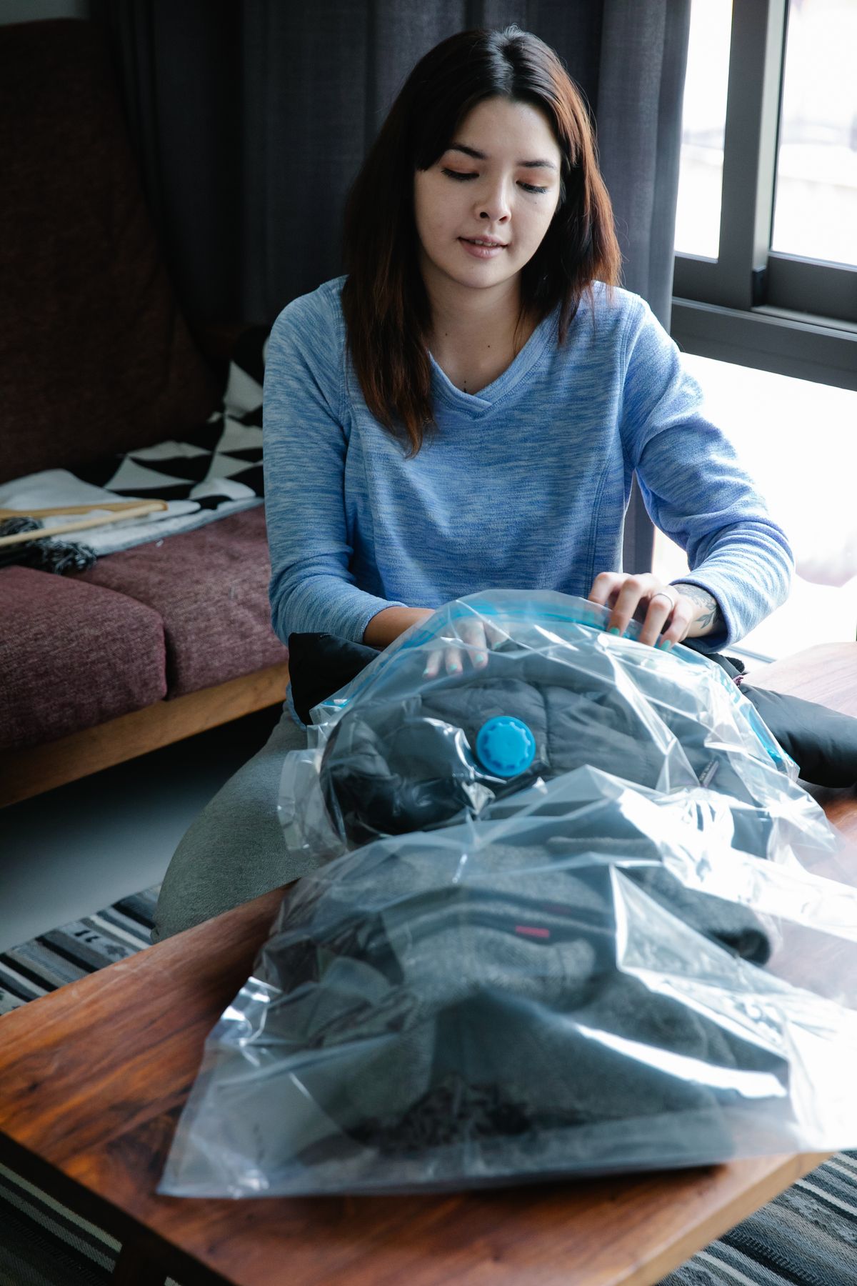 Woman packing belongings in vacuum seal bags for organized storage and quality testing