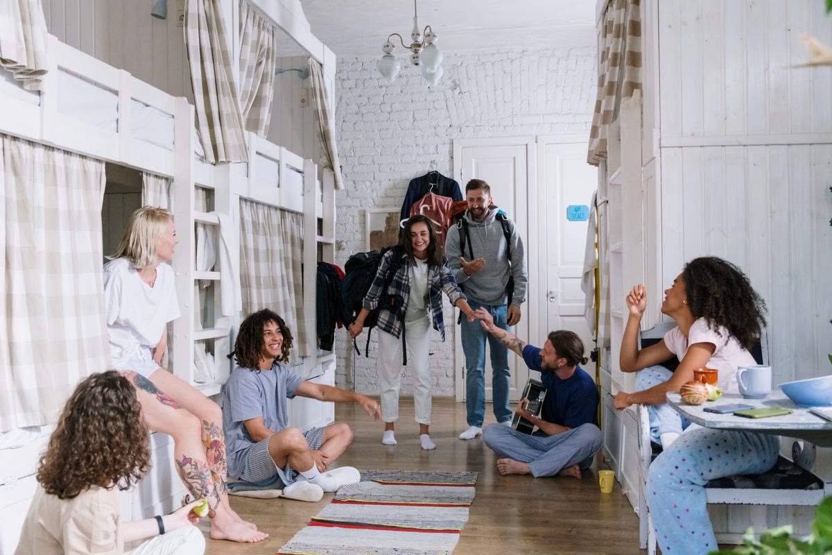 College students organizing dorm room with vacuum storage bags to maximize limited space