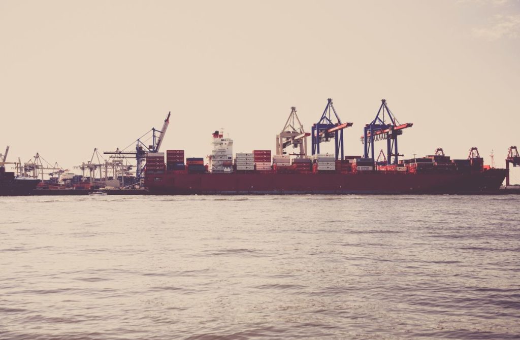 Cargo ship loaded with shipping containers at port — Incoterms guide for vacuum bag imports