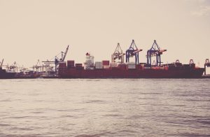 Cargo ship loaded with shipping containers at port — Incoterms guide for vacuum bag imports