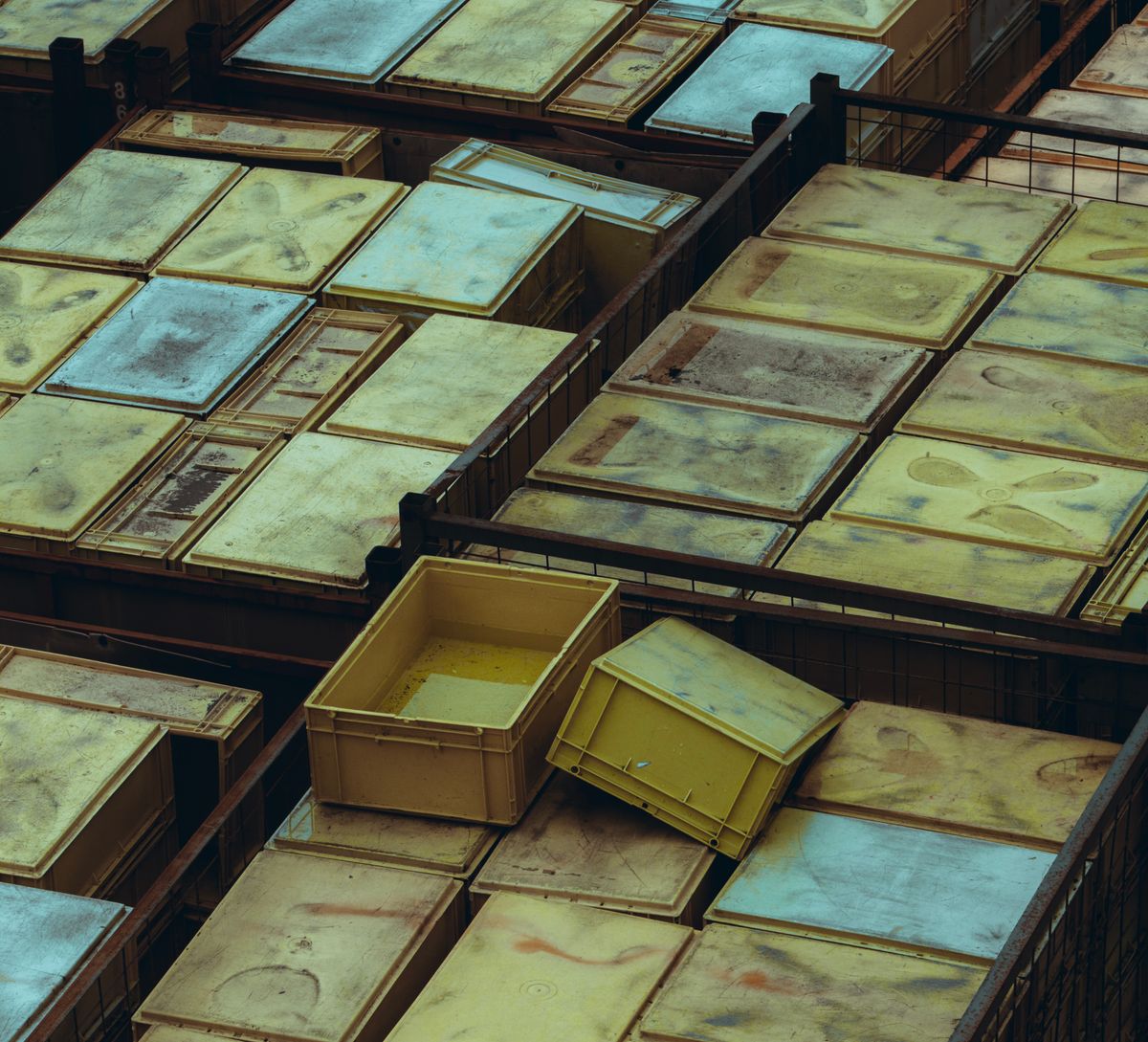 Stacked plastic storage bins in a warehouse alongside vacuum compression bags
