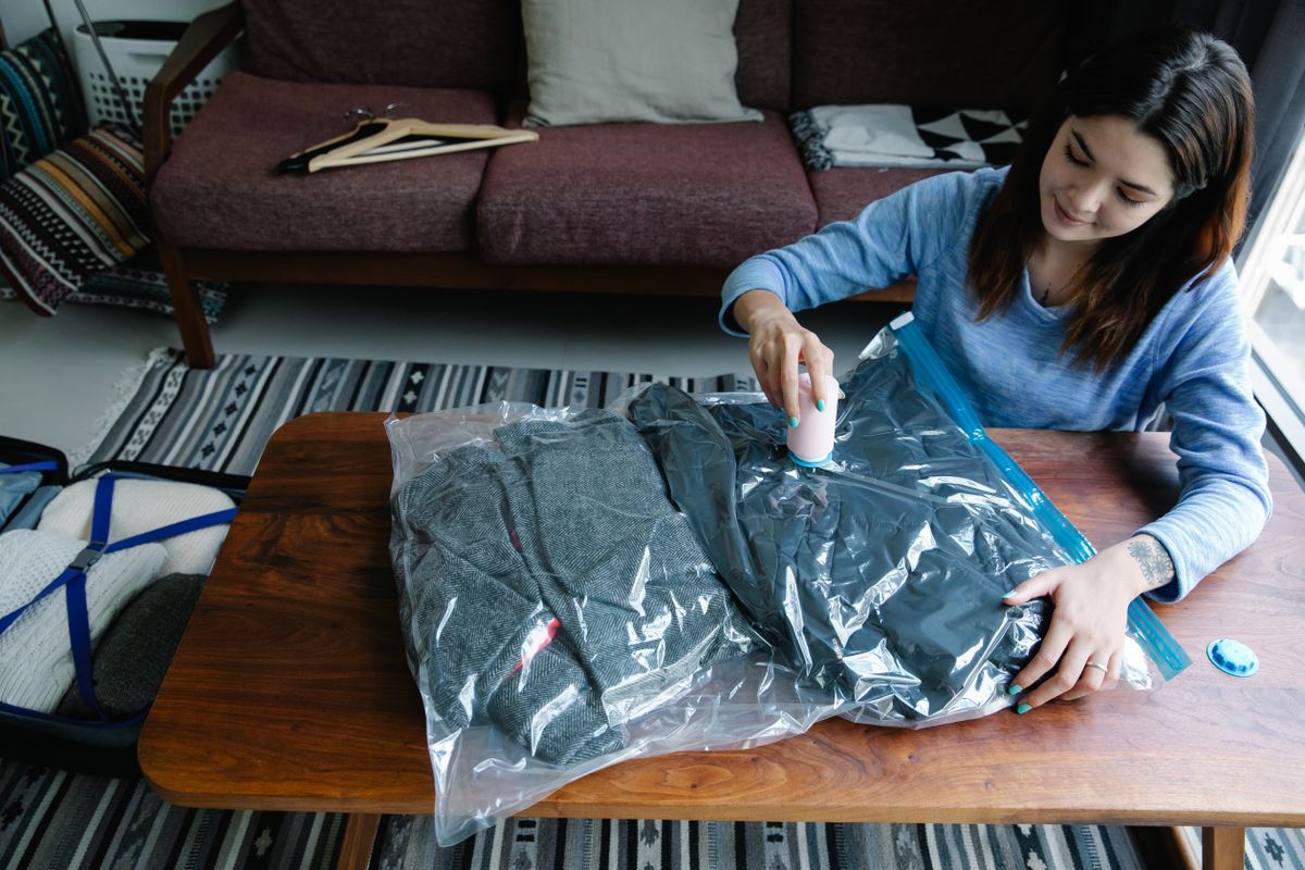Close-up of vacuum bag being sealed with vacuum cleaner for maximum compression
